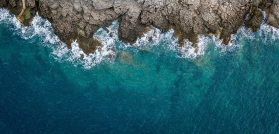Aerial shot of waves crashing on rocks